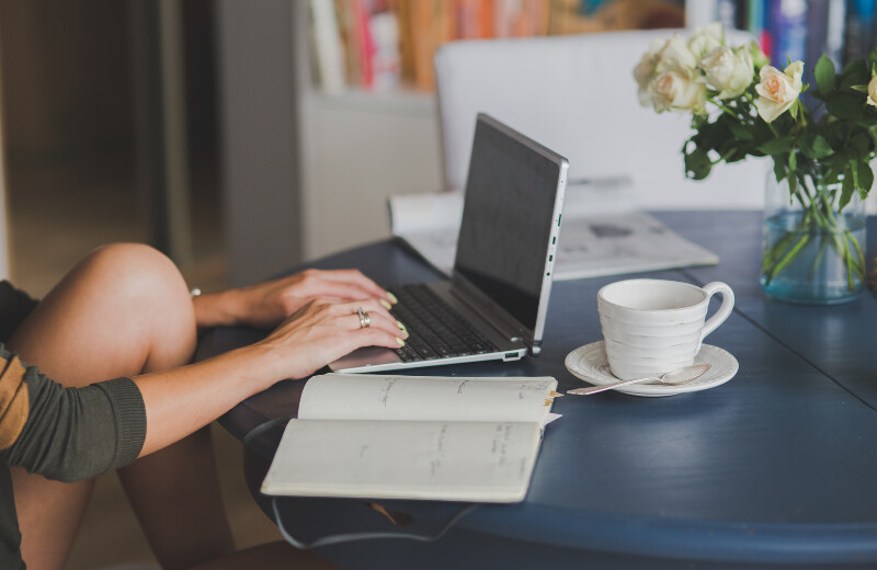 Researching, with diary and cup next to the computer